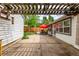 Concrete backyard patio under pergola with patio furniture and a red umbrella at 1341 Chester St, Aurora, CO 80010