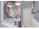 Stylish bathroom featuring a circular mirror, a modern sink, and a tiled shower with a gray curtain at 1341 Chester St, Aurora, CO 80010