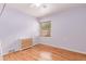 Cozy bedroom featuring hardwood floors, a window with blinds, and neutral wall color at 1341 Chester St, Aurora, CO 80010