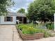 Inviting home showcasing a delightful front yard with raised flower beds and a cozy porch at 1341 Chester St, Aurora, CO 80010