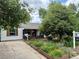 Charming home featuring raised garden beds with vibrant flowers and mature trees in the front yard at 1341 Chester St, Aurora, CO 80010