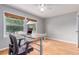 Bright office space with hardwood floors, a large window, and a modern adjustable-height desk at 1341 Chester St, Aurora, CO 80010