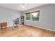 Bright office space with hardwood floors, a large window, and a modern adjustable-height desk at 1341 Chester St, Aurora, CO 80010