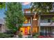 Modern two-story home with stone accents, a red front door, and a small balcony overlooking the landscaped front yard at 3845 N Raleigh St, Denver, CO 80212
