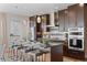 Stylish kitchen features stainless appliances, dark cabinets, an island with bar seating, and designer pendant lights at 3845 N Raleigh St, Denver, CO 80212