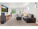 Bright living room featuring a modern sofa, sleek entertainment center, and abundant natural light at 3845 N Raleigh St, Denver, CO 80212