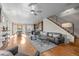 Open-concept living room with hardwood floors, modern staircase, and seamless flow to dining area and kitchen at 3845 N Raleigh St, Denver, CO 80212