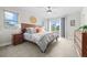 Comfortable main bedroom showcasing a wooden bed frame, ceiling fan, and sliding door to a balcony at 3845 N Raleigh St, Denver, CO 80212