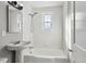 Clean bathroom with white tile, pedestal sink, and combined tub and shower at 1241 Locust St, Denver, CO 80220