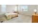 Bright bedroom features large windows, neutral paint and carpet, and a side table at 6070 Long Branch Dr, Parker, CO 80134