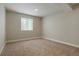 Bright bedroom featuring neutral walls, cozy carpet, and a window for natural light at 6070 Long Branch Dr, Parker, CO 80134