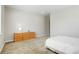 Bright bedroom with a light colored carpet and a wooden dresser with a lamp at 6070 Long Branch Dr, Parker, CO 80134