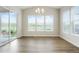 The dining room features a sliding glass door, a wall of windows, a chandelier, and hardwood floors at 6070 Long Branch Dr, Parker, CO 80134