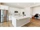 A modern kitchen with stainless steel appliances, white cabinets and countertop, and wood flooring at 6070 Long Branch Dr, Parker, CO 80134