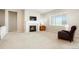 Cozy living room with a fireplace, TV, neutral colors, and a large window allowing for plenty of natural light at 6070 Long Branch Dr, Parker, CO 80134