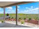A covered patio presents views of a manicured yard and a grassy field in the distance at 6070 Long Branch Dr, Parker, CO 80134