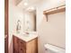 Well-lit half bathroom with a wood vanity, neutral walls, and classic fixtures at 3240 E 128Th Pl, Thornton, CO 80241