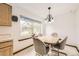 Cozy dining area with a wood table, comfortable chairs, and a bright window at 3240 E 128Th Pl, Thornton, CO 80241