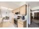 Bright kitchen with white appliances, wood cabinets and a view into the dining area at 3240 E 128Th Pl, Thornton, CO 80241