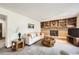 Spacious living room featuring a brick fireplace, built-in shelves, and comfortable seating at 3240 E 128Th Pl, Thornton, CO 80241