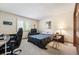 Cozy bedroom with neutral carpet, a dark bedspread, desk, and a window bringing in natural light at 7900 E Dartmouth Ave # 75, Denver, CO 80231