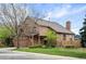 Inviting two-story home featuring a brick chimney, covered porch and lush, well-maintained front lawn at 7900 E Dartmouth Ave # 75, Denver, CO 80231
