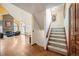 Inviting foyer with hardwood floors, staircase, and view into the spacious living room with a brick fireplace at 7900 E Dartmouth Ave # 75, Denver, CO 80231