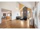 Open concept living room featuring hardwood floors, a brick fireplace, and large arch windows at 7900 E Dartmouth Ave # 75, Denver, CO 80231