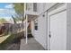 Exterior unit entrance with white door and siding, next to lawn and fence at 4670 W Nevada Pl # A, Denver, CO 80219