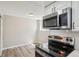 Kitchen features stainless steel microwave, electric range, and sleek, white cabinets at 4670 W Nevada Pl # A, Denver, CO 80219