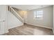 Bright living room with wood floors, a staircase, and a large window at 4670 W Nevada Pl # A, Denver, CO 80219