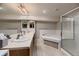 Bright bathroom featuring a glass enclosed shower, corner tub, and dual sinks at 20510 Oakbrook Ln, Parker, CO 80138