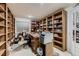 Home office with custom built-in bookshelves, neutral walls, and a work desk at 20510 Oakbrook Ln, Parker, CO 80138