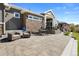 Expansive backyard patio with stone accents, comfortable seating, and well-manicured lawn at 32 Latigo Pl, Littleton, CO 80123