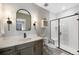 A modern bathroom features a sleek vanity with an elegant black framed shower at 32 Latigo Pl, Littleton, CO 80123