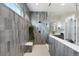 This shower features sleek gray tiling, a built-in bench, and dual shower heads at 32 Latigo Pl, Littleton, CO 80123