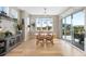 Bright dining area features modern lighting, wooden table, and sliding glass doors leading to outdoor space at 32 Latigo Pl, Littleton, CO 80123