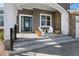 Inviting covered front porch with seating, stone accents, and manicured landscaping at 32 Latigo Pl, Littleton, CO 80123