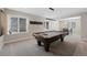 This large recreation room features a billiard table, seating area, and windows at 32 Latigo Pl, Littleton, CO 80123