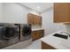 Bright laundry room with updated appliances, cabinets, and countertop space at 32 Latigo Pl, Littleton, CO 80123