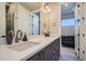 Double sink bathroom vanity with modern fixtures and bright lighting, and a view into a living area at 1583 Grove St # 5, Denver, CO 80204