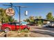Exterior view of a brewery, featuring a sign, outdoor seating area, and various parked cars on a sunny day at 1583 Grove St # 5, Denver, CO 80204