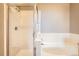 Bright bathroom features a glass-enclosed shower and a separate soaking tub with white tile surround at 10176 Park Meadows Dr # 2403, Lone Tree, CO 80124