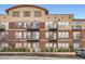 Close up of a brick apartment building with multiple balconies, windows, and a small tree at 10176 Park Meadows Dr # 2403, Lone Tree, CO 80124