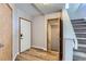 Inviting foyer with wood-look flooring, staircase, and convenient coat closet at 12144 Newport Dr, Brighton, CO 80602