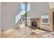 Bright living room featuring soaring ceilings, large windows, and a cozy brick fireplace at 12144 Newport Dr, Brighton, CO 80602