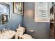 Stylish powder room featuring a round mirror, artwork, and blue accent wall at 1145 S Logan St, Denver, CO 80210