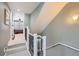 Hallway with stairs and view of bedroom with ceiling fan and shuttered windows at 1145 S Logan St, Denver, CO 80210
