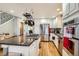 Bright kitchen features stainless steel appliances, center island with cooktop and hanging pot rack, and hardwood floors at 1145 S Logan St, Denver, CO 80210