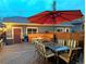 Outdoor wood deck with open fire pit, string lights, seating under a large umbrella at 1145 S Logan St, Denver, CO 80210